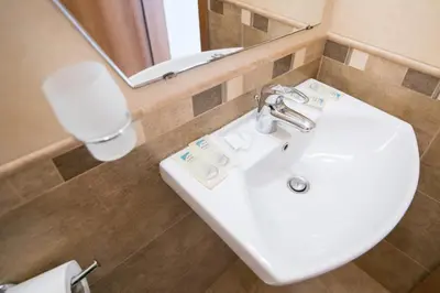 a bathroom with a white sink and a mirror at ТРОПИКАНА in Primorsko