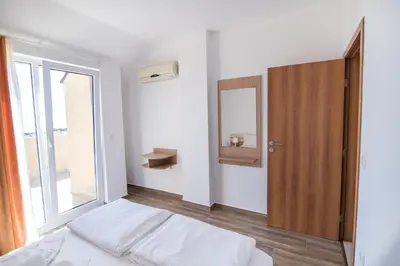 a bedroom with a bed and a mirror and a window at ТРОПИКАНА in Primorsko