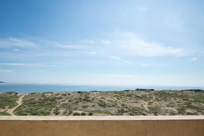 a view of a hill with the ocean in the background at ТРОПИКАНА in Primorsko