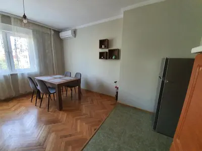 a dining room with a table and chairs and a refrigerator at Danny apartment in Burgas City