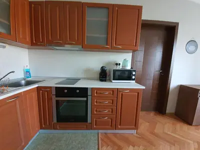 a small kitchen with wooden cabinets and a microwave at Danny apartment in Burgas City