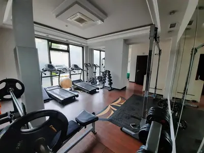a gym with several treadmills and machines in a room at Private Apartments by the sea with a large terrace in Apart hotel! in Pomorie