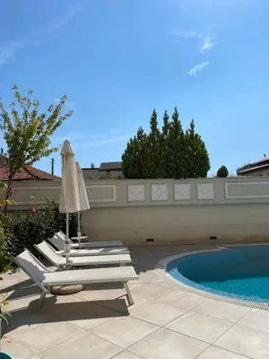 a group of lounge chairs and an umbrella next to a pool at Private Apartments by the sea with a large terrace in Apart hotel! in Pomorie