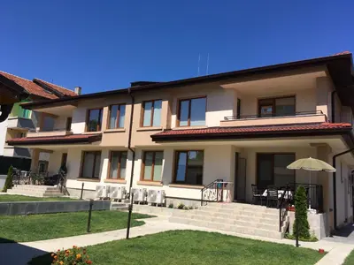 a large building with a patio and an umbrella at GUEST HOUSE ZORNICA in OBZOR in Obzor