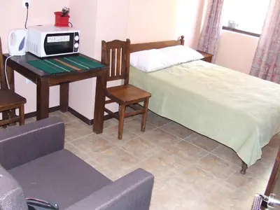 a bedroom with a bed and a desk with a microwave at Varnaflats Guest Rooms in Varna City