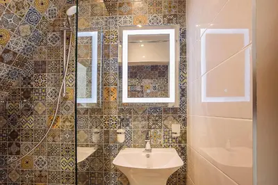 a bathroom with a sink and a mirror at Deluxe studio Center city in Varna City