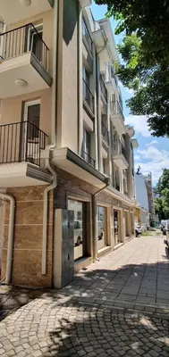 a building on a cobblestone street in a city at Deluxe studio Center city in Varna City