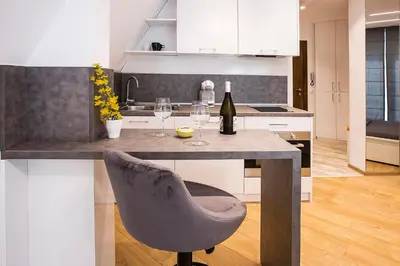 a kitchen with a table with two glasses of wine at Deluxe studio Center city in Varna City