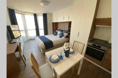 a hotel room with a bed and a table with a kitchen at Studio 13 in Varna City