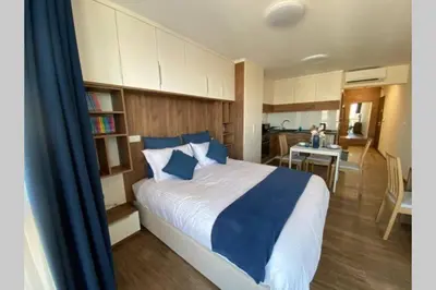 a bedroom with a large bed and a kitchen at Studio 13 in Varna City