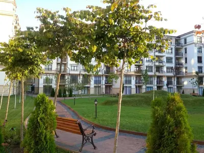 a park bench in front of a large building at Айвазовский парк in Pomorie