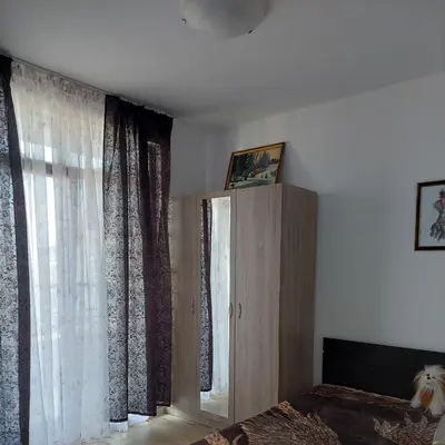 a bedroom with a bed and a large window at Айвазовский парк in Pomorie