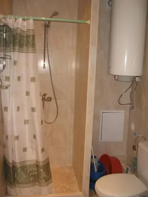 a bathroom with a shower with a curtain and a toilet at Айвазовский парк in Pomorie