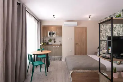 a small room with a bed and a table and a kitchen at The Cozy Studio, Varna City Centre in Varna City