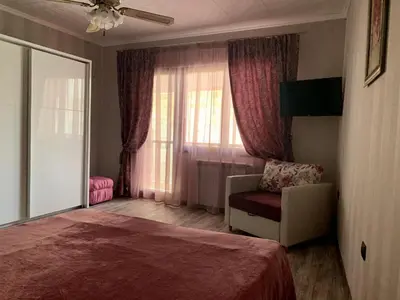 a bedroom with a bed and a chair and a window at Boutique House Belevi in Nesebar