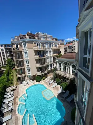 an overhead view of a swimming pool with chairs and buildings at Dawn Park Deluxe in Sunny Beach
