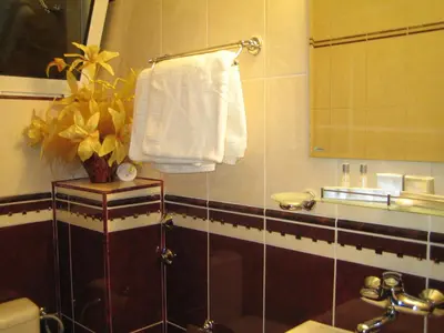 a bathroom with a sink and a white towel at Хотел БУТИК ИМПЕРИАЛ in Primorsko