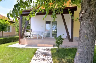 a patio of a house with a table and chairs at BulgariaVilla - Sunny Hills Villas in Bryastovets