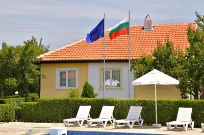 a group of chairs and flags in front of a house at BulgariaVilla - Sunny Hills Villas in Bryastovets
