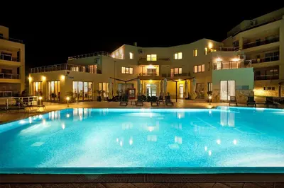 a large swimming pool in front of a building at night at Byala Panorama Resort in Byala