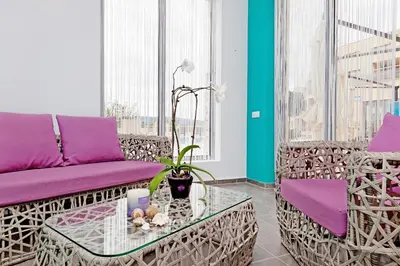 a living room with purple chairs and a table at Byala Panorama Resort in Byala