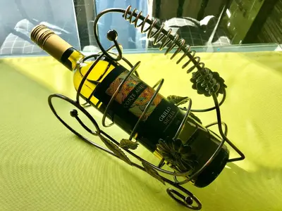 a bottle of wine in a rack on a table at Avelov Art Apartment in Burgas City