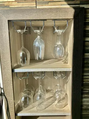 a wooden cabinet with wine glasses on it at Avelov Art Apartment in Burgas City