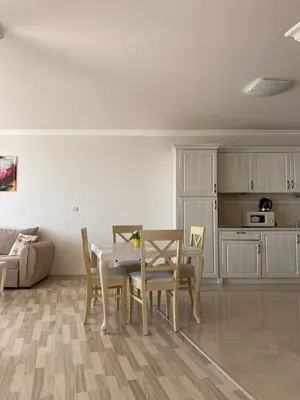 a living room with a table and chairs and a kitchen at Private Super apartments by sea in Apart Hotel ! in Pomorie