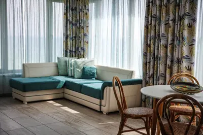 a couch in a room with a table and chairs at Villa Flora in Sozopol