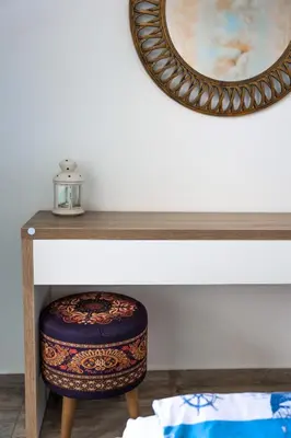 a stool sitting under a table with a mirror at Villa Flora in Sozopol
