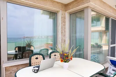 a balcony with a table with a laptop on it at Villa Flora in Sozopol