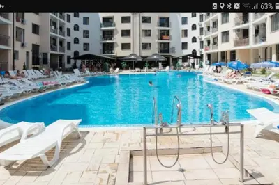 a large blue swimming pool with white chairs and buildings at Avalon appartament da Lary in Sunny Beach