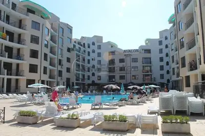 a pool with chairs and umbrellas next to some buildings at Avalon appartament da Lary in Sunny Beach