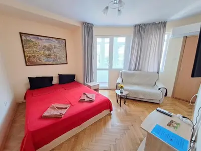 a bedroom with a red bed and a chair at Варна Хостел in Varna City