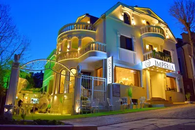 a large white building with a lit up at Hotel IMPERIA in Varna City