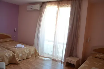 a bedroom with two beds and a large window at Sania in Obzor