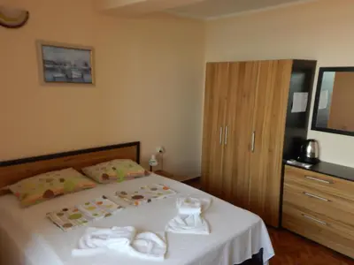 a bedroom with a bed with towels on it at Tony Guest House in Sozopol