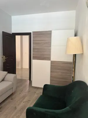 a living room with a green chair and a lamp at Апартамент на солнечном берегу in Sunny Beach