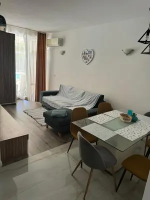 a living room with a table and chairs and a bed at Апартамент на солнечном берегу in Sunny Beach
