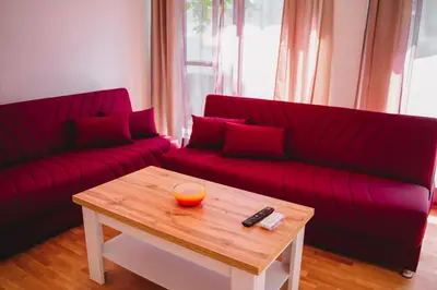 a living room with two red couches and a coffee table at Andreya's Sea apartment-Beach, Sea garden ,Old Town, Free Parking, Free EVcharging Station in Varna City