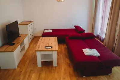 a living room with a red couch and a table at Andreya's Sea apartment-Beach, Sea garden ,Old Town, Free Parking, Free EVcharging Station in Varna City