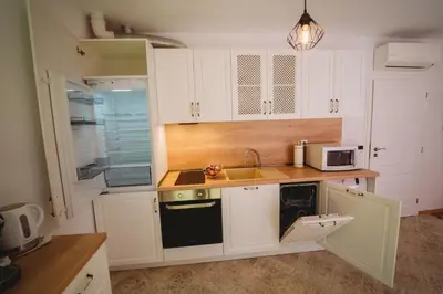 a kitchen with white cabinets and a sink and a microwave at Andreya's Sea apartment-Beach, Sea garden ,Old Town, Free Parking, Free EVcharging Station in Varna City