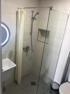 a shower with a glass door next to a sink at Hotel Pacific Palma in Sunny Beach