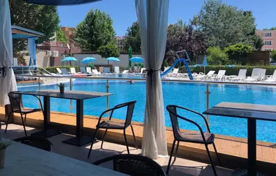 a patio with tables and chairs next to a swimming pool at Hotel Pacific Palma in Sunny Beach
