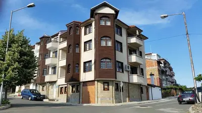 a tall building with a clock tower on a street at Апартамент КИМАКО, 100м2 на цена за хотелска стая за двама in Tsarevo