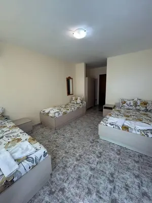 a room with three beds in a room at Guest Rooms Nia Elis Kiten in Burgas City