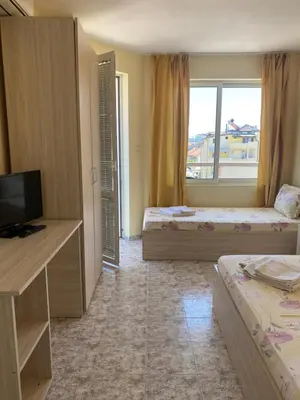 a hotel room with two beds and a television at Guest Rooms Nia Elis Kiten in Burgas City