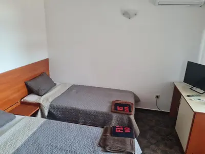 a room with two beds and a desk with a computer at Алми Almi in Sveti Vlas