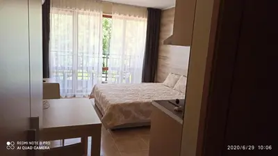 a bedroom with a bed and a window and a table at River park in Sunny Beach