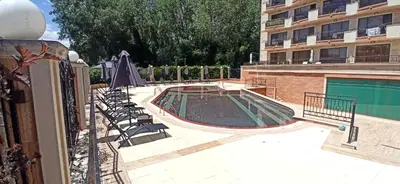 a swimming pool with chairs next to a building at River park in Sunny Beach